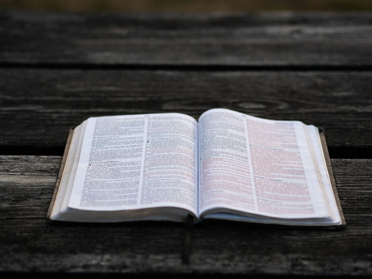 An open Bible on a dark wooden table